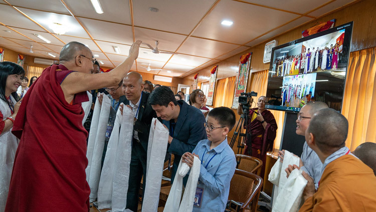 Thánh Đức Đạt Lai Lạt Ma vẫy tay chào những người tại Hà Nội, TP. HCM và Hải Phòng tham dự hội nghị truyền hình trực tiếp với một nhóm người Việt Nam tại Dharamsala, HP, Ấn Độ vào 21 tháng 5, 2018. Ảnh của Tenzin Choejor