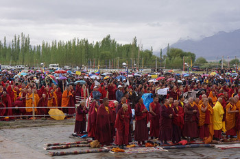 Các thành viên của khán giả đứng dưới mưa tại Sân bãi Shiwatsel khi Thánh Đức Đạt Lai Lạt Ma quang lâm đến để khai mạc cho Pháp hội bốn ngày ở Leh, Ladakh, J&K, Ấn Độ, vào 4 tháng 8, 2012. Ảnh / Jeremy Russell / VPĐLLM
