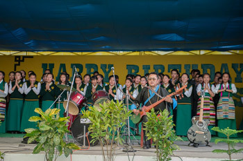 Một ban nhạc sinh viên và dàn hợp xướng dẫn đầu một bài hát khi Thánh Đức Đạt Lai Lạt Ma và Đức Tổng Giám mục Desmond Tutu quang lâm đến sân bóng rổ tại Trường Làng Trên của Trẻ em Tây Tạng (TCV) ở Dharamsala, HP, Ấn Độ vào 23 tháng 4, 2015. Ảnh / Tenzin Choejor / VPĐLLM