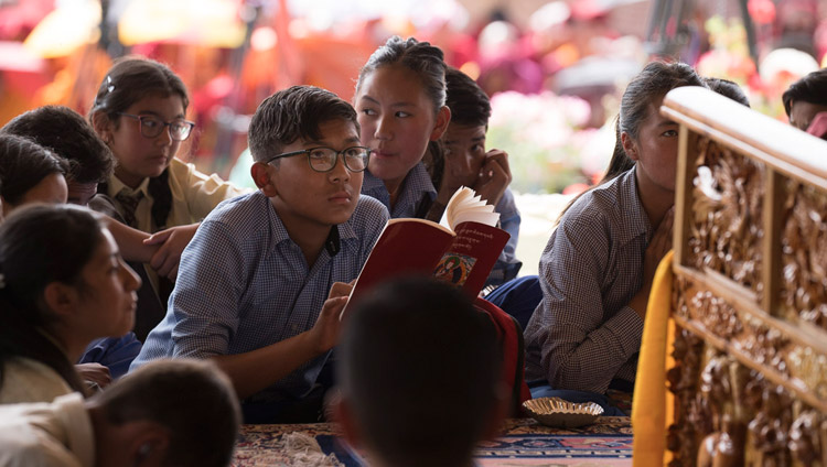 Các em học sinh ngồi dưới chân Đức Đạt Lai Lạt Ma sau khi Ngài yêu cầu họ ngồi trước mặt Ngài để tránh ánh nắng mặt trời vào ngày cuối cùng của pháp hội tại Leh, Ladakh, J & K, Ấn Độ vào ngày 30 tháng 7 năm 2017. Ảnh của Tenzin Choejor / VPĐLLM