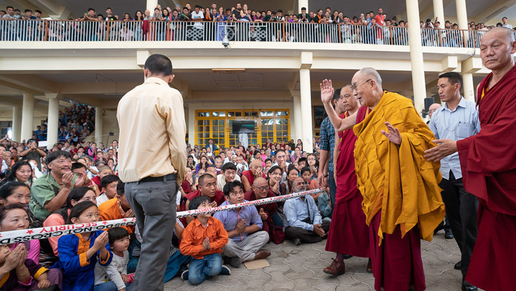 Thánh Đức Đạt Lai Lạt Ma vẫy tay chào các thành viên của khán giả ngồi trong sân Chùa Chính Tây Tạng khi Ngài trở về dinh thự của mình vào lúc kết thúc Pháp hội dành cho Thanh thiếu niên học sinh Tây Tạng tại Chùa Tây Tạng Chính ở Dharamsala, Ấn Độ ngày 8 tháng 6, 2018. Ảnh bởi Tenzin Choejor