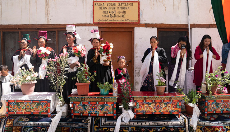 Người dân địa phương đứng cạnh chiếc bàn chạm khắc, mang hoa trong chậu để cung đón Thánh Đức Đạt Lai Lạt Ma quang lâm đến Thung lũng Nubra ở Ladakh, J & K, Ấn Độ vào 12 tháng 7, 2018. Ảnh của Tenzin Choejor