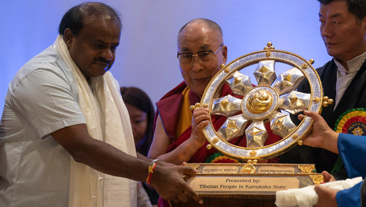 Thánh Đức Đạt Lai Lạt Ma tặng một Bánh Xe Pháp Luân cho Bộ trưởng Karnataka, HD Kumaraswamy với lòng biết ơn đến công chúng Karnatakan trong chương trình “Cảm ơn Karnataka” ở Bengaluru, Karnataka, Ấn Độ vào 10 tháng 8, 2018. Ảnh của Tenzin Choejor