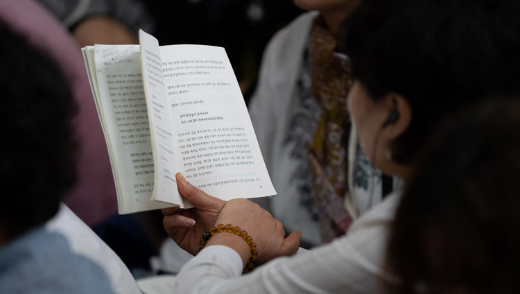 Một thành viên của khán giả đang theo dõi bản văn trong ngày thứ hai của Pháp Hội của Ngài tại Chùa Tây Tạng chính ở Dharamsala, HP, Ấn Độ vào 05 tháng 9, 2018. Ảnh của Tenzin Choejor