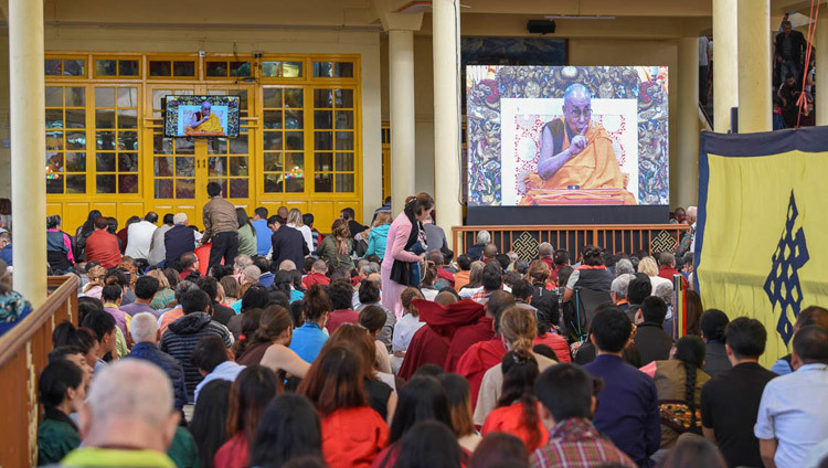 Nhiều người trong đám đông tụ tập trong sân Chùa chính Tây Tạng đang theo dõi Thánh Đức Đạt Lai Lạt Ma thuyết pháp trên màn ảnh rộng ở Dharamsala, HP, Ấn Độ vào 3 tháng 10, 2018. Ảnh của Tenzin Phende / DIIR