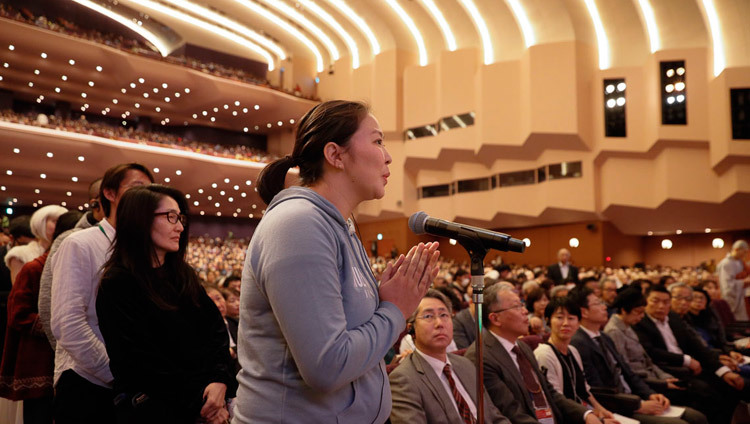 Một thành viên của khán giả hỏi Thánh Đức Đạt Lai Lạt Ma một câu hỏi trong cuộc đối thoại giữa Khoa học hiện đại và Khoa học Phật giáo tại Hội trường Quốc gia ở Yokohama, Nhật Bản vào 16 tháng 11, 2018. Ảnh của Tenzin Jigme