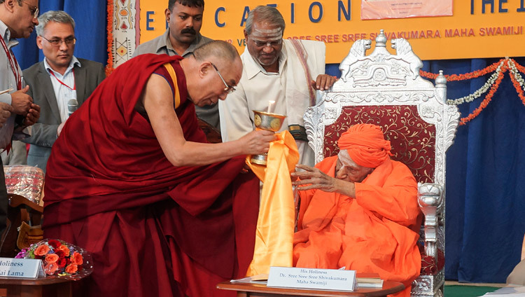 Thánh Đức Đạt Lai Lạt Ma dâng đèn bơ cho Sree Shivakumara Swamiji trong chuyến viếng thăm Đại học Tumkur ở Tumkar, Karnataka, Ấn Độ vào ngày 27 tháng 11 năm 2012. Ảnh của Jeremy Russell