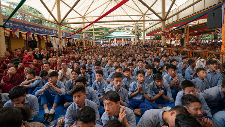Các sinh viên trẻ Tây Tạng ngồi trong sân Chùa chính Tây Tạng đang xem Lễ cúng dường Trường Thọ cho Thánh Đức Đạt Lai Lạt Ma trên màn hình lớn ở Dharamsala, HP, Ấn Độ vào 17 tháng 5, 2019. Ảnh của Tenzin Choejor
