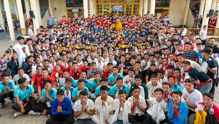 Thánh Đức Đạt Lai Lạt Ma chụp ảnh chung với 23 đội Thanh niên Tây Tạng đến từ Châu Âu, Hoa Kỳ và nhiều vùng khác của Ấn Độ, những người đang tham gia giải bóng đá Cúp vàng Tưởng niệm Gyalyum Chenmo (Người Mẹ Vĩ Đại) lần thứ 25 tại sân Chùa Chính Tây Tạng ở Dharamsala, HP, Ấn Độ vào 5 tháng 6, 2019. Ảnh của Tenzin Choejor