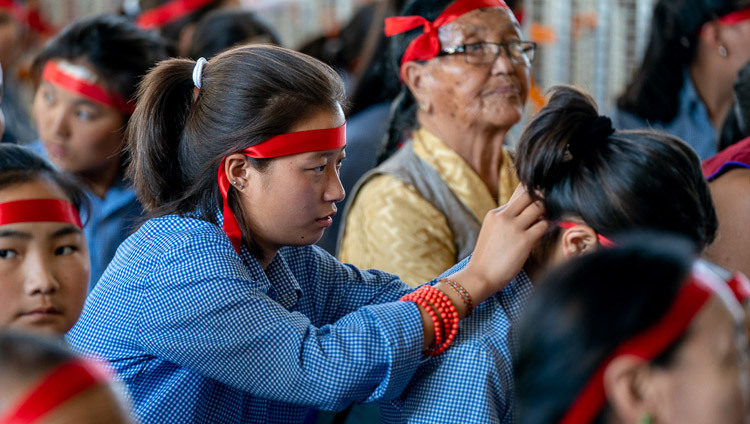 Các sinh viên Tây Tạng trong số khán giả đang chuẩn bị các nghi thức che mắt được sử dụng trong Lễ quán đảnh Quán Thế Âm do Thánh Đức Đạt Lai Lạt Ma ban truyền tại Chùa Tây Tạng Chính ở Dharamsala, HP, Ấn Độ vào 5 tháng 6, 2019. Ảnh của Tenzin Choejor