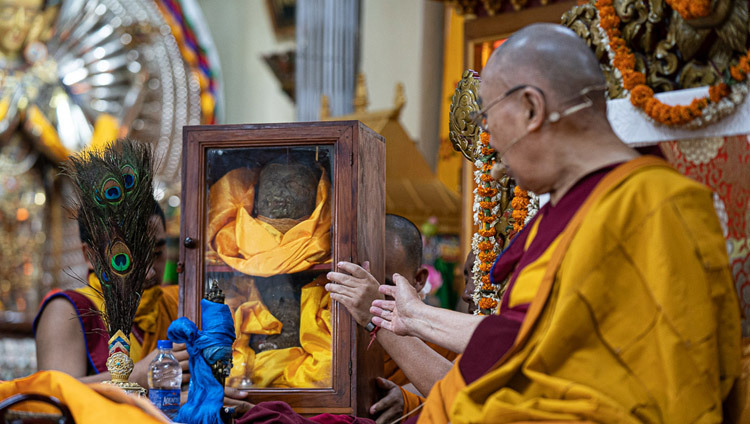 Thánh Đức Đạt Lai Lạt Ma ra cử chỉ về phía chiếc hộp bằng thủy tinh đựng các mảnh tượng của Đức Quán Thế Âm bị phá hủy trong cuộc cách mạng văn hóa nhưng sau đó đã được giải cứu và mang đến Ấn Độ khi Ngài giải thích về lễ quán đảnh Quan Thế âm tại Chùa Chính Tây Tạng ở Dharamsala, HP, Ấn Độ vào 5 tháng 6, 2019 Ảnh của Tenzin Choejor