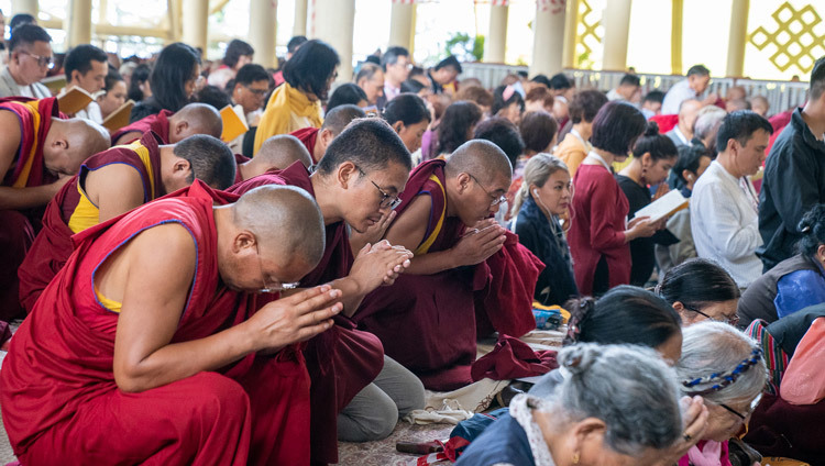 Các thành viên của đám đông quỳ gối khi Thánh Đức Đạt Lai Lạt Ma hướng dẫn hội chúng thực hiện nghi thức phát Bồ Đề Tâm vào ngày thứ ba của Pháp Hội tại chùa Tây Tạng Chính ở Dharamsala, HP, Ấn Độ vào 6 tháng 9, 2019. Ảnh của Matteo Passigato