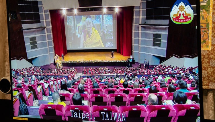Quang cảnh hội trường ở Đài Bắc, Đài Loan được chiếu trên màn hình TV trước mặt Thánh Đức Đạt Lai Lạt Ma trong ngày thứ ba của đợt thuyết Pháp trực tuyến từ Dinh thự của Ngài ở Dharamsala, HP, Ấn Độ vào 4 tháng 10, 2020. Ảnh của Thượng toạ Tenzin Jamphel