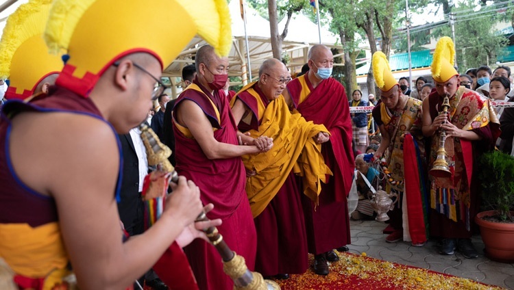 Thánh Đức Đạt Lai Lạt Ma đi bộ qua sân Chùa Chính Tây Tạng trên đường quang lâm đến tham dự Lễ Cầu nguyện Trường thọ do Tổ chức Bảo tồn Truyền thống Đại thừa (FPMT) dâng lên cúng dường Ngài ở Dharamsala, HP, Ấn Độ vào 24 tháng 5, 2023. Ảnh của Tenzin Choejor