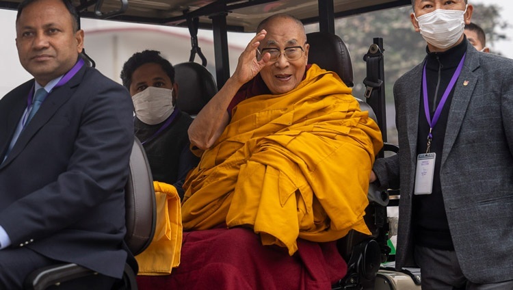 Thánh Đức Đạt Lai Lạt Ma vẫy tay chào Hội chúng khi Ngài đi xe golf quay trở lại Tu viện Tây Tạng vào lúc kết thúc Lễ Trường Thọ tại Sân bãi Kalachakra ở Bồ Đề Đạo Tràng, Bihar, Ấn Độ vào 1 tháng 1, 2024. Ảnh của Tenzin Choejor